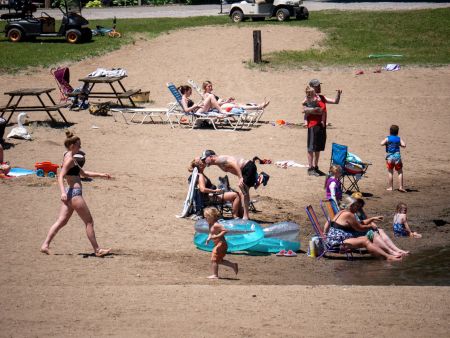 Indian Springs Campground & Water Park - Family enjoying the new Splash Springs Floating Water Park with water slide, beach area, and scenic fishing lakes in a serene forest setting. Perfect for camping, fishing, and water fun near Fort Wayne.