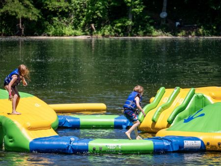 Indian Springs Campground & Water Park - Family enjoying the new Splash Springs Floating Water Park with water slide, beach area, and scenic fishing lakes in a serene forest setting. Perfect for camping, fishing, and water fun near Fort Wayne.